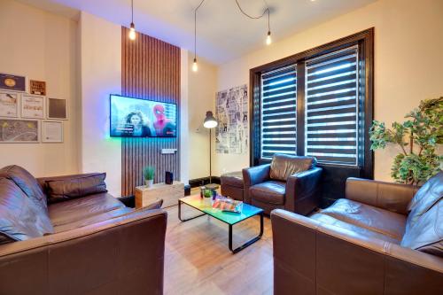 a living room with two couches and a tv at Newcastle CITY APT35,FREE STREET PARKING,4 BEDROOM HOUSE,8 SINGLE BEDS,FULL KITCHEN,ALL ROOMS WITH TVs,NETFLIX in Newcastle upon Tyne