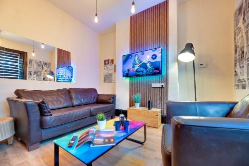a living room with a couch and a table at Newcastle CITY APT35,FREE STREET PARKING,4 BEDROOM HOUSE,8 SINGLE BEDS,FULL KITCHEN,ALL ROOMS WITH TVs,NETFLIX in Newcastle upon Tyne