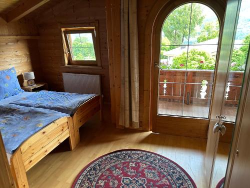 a bedroom with a bed and a window and a door at Ferienwohnung Volgger in Mils bei Hall