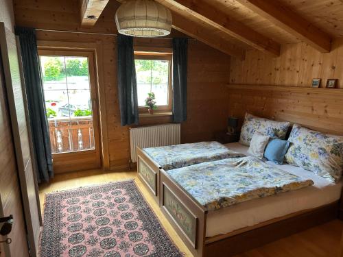 a bedroom with two beds in a room with wooden walls at Ferienwohnung Volgger in Mils bei Hall