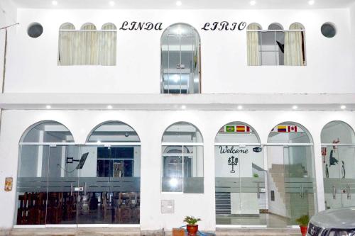 un gran edificio blanco con arcos y ventanas en HOSPEDAJE LINDA LIRIO, en Paracas