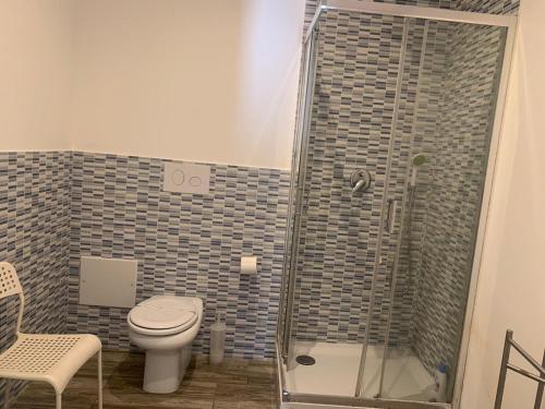 a bathroom with a toilet and a glass shower at BorgoMarino's Room in Cefalù