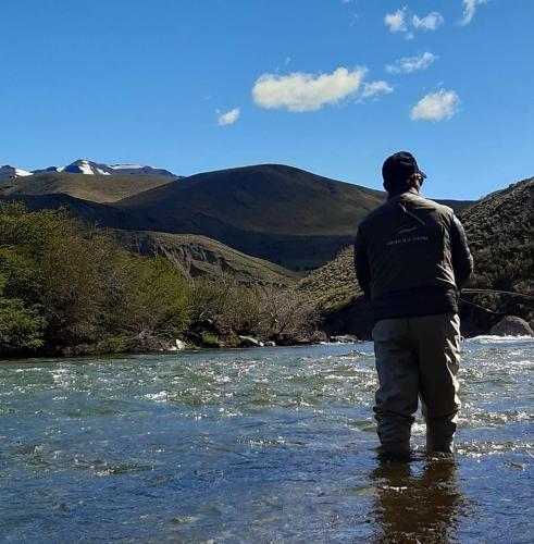 a man standing in the water in a river at BARDAS del LIMAY DORMI-con HIDROMASAJE - totalmente EQUIPADO in Plottier