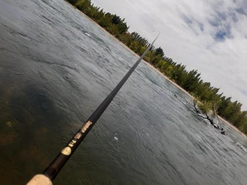a person holding a fishing pole in the water at BARDAS del LIMAY DORMI-con HIDROMASAJE - totalmente EQUIPADO in Plottier
