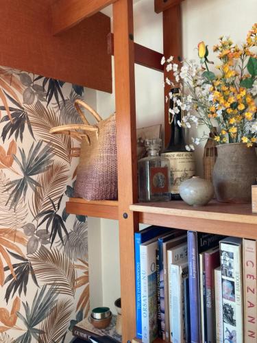 a book shelf with books and flowers on it at Chambre privée dans Maison Familiale in Veyrier-du-Lac