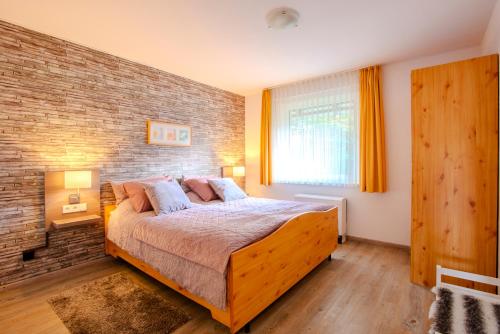 1 dormitorio con 1 cama grande y pared de ladrillo en Ferienhaus Hedrich, en Assinghausen