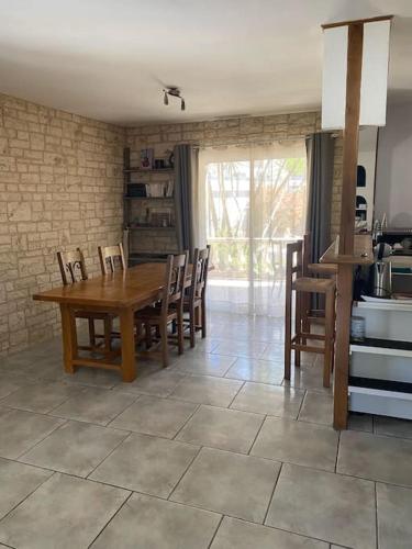 une salle à manger avec une table et des chaises en bois dans l'établissement Maison près des vignes, à Castelnau-de-Guers