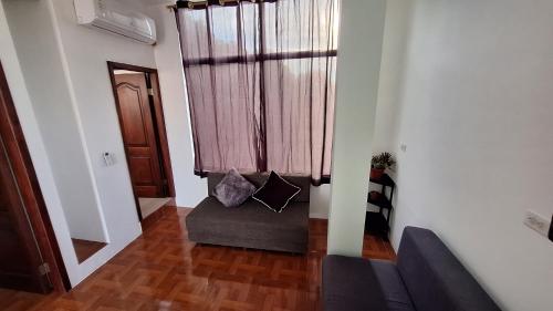 ein Wohnzimmer mit einer Couch vor einem Fenster in der Unterkunft Galápagos Volcanic in Puerto Ayora