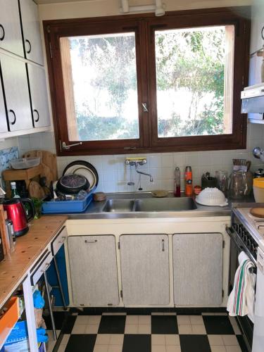 a kitchen with a sink and two windows at Chambre privée dans Maison Familiale in Veyrier-du-Lac