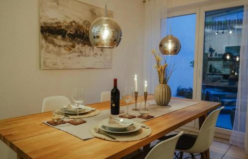 a dining room table with a bottle of wine and candles at Müllers Gästehaus in Berg