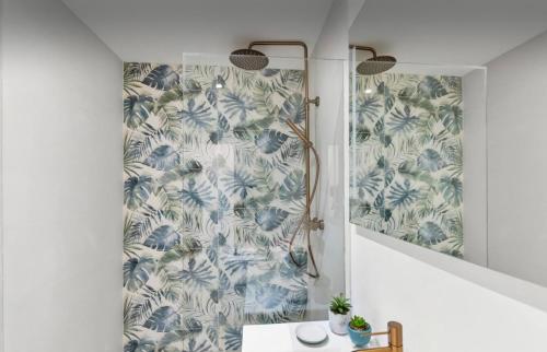 a bathroom with a shower with blue and white wallpaper at La Créola New! Grand Case - vue mer - appart 4p - King size in Grand Case
