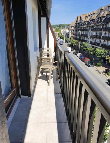 d'un balcon avec un banc et une rue de la ville. dans l'établissement Super appartement en plein cœur de Deauville, à Deauville