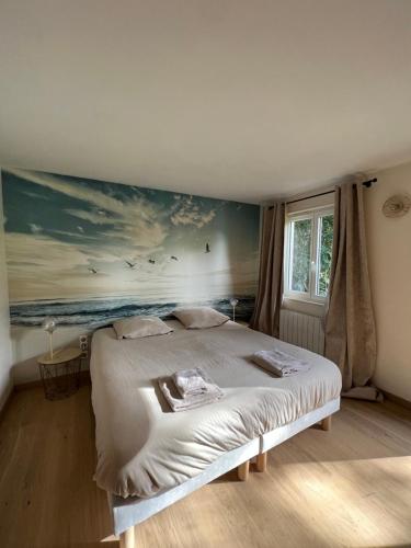 une chambre avec un lit avec un tableau sur le mur dans l'établissement Le clos de Lily, à Coudray-Rabut