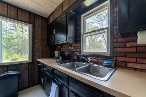 a kitchen with a sink and a brick wall at Mud Creek Cottage in Cheboygan