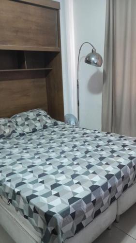 a bed with a black and white checkered mattress at Suíte Ano Bom in Barra Mansa