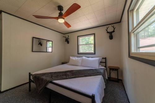 a bedroom with a bed with a ceiling fan at Mud Creek Cottage in Cheboygan