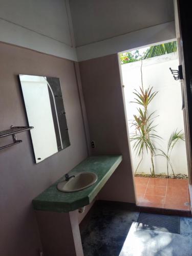 a bathroom with a sink and a mirror at Cabinas Tropicales in Puerto Jiménez