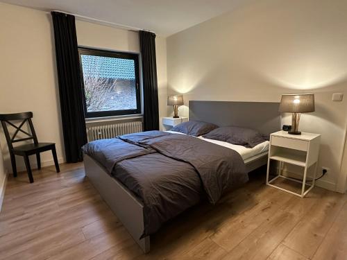 Un dormitorio con una cama grande y una ventana en Villa Im Bongert - Tor zum Nationalpark Eifel, en Hellenthal