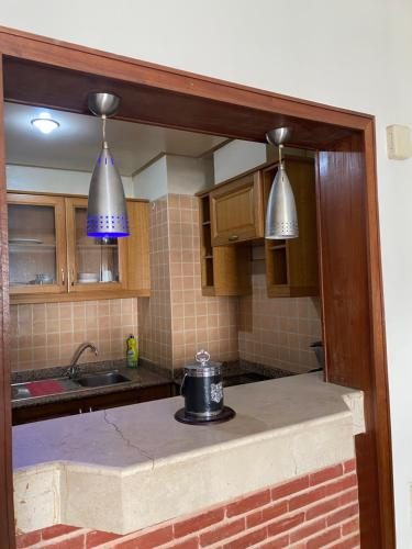 uma cozinha com duas luzes e uma panela no balcão em Résidence marina agadir em Agadir