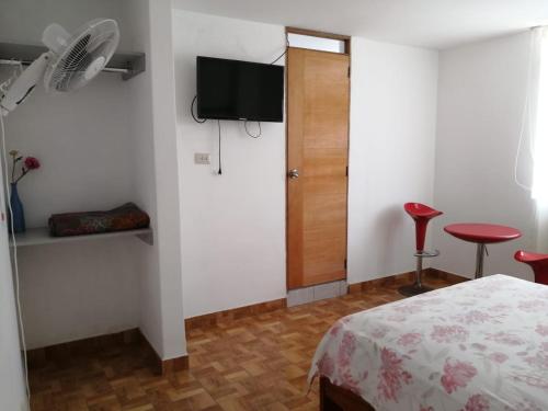 Dormitorio con cama, TV y taburete en Hotel Huanchaco en Trujillo