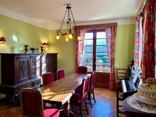 Yenne的住宿－Chambre d’hôte à Yenne avec grand salon，一间带木桌和椅子的用餐室