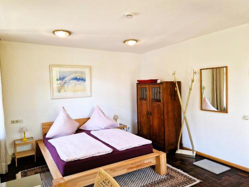 um quarto com uma cama com almofadas cor-de-rosa em Freiburg citynah - hell, ruhig, gemütlich em Friburgo em Brisgóvia