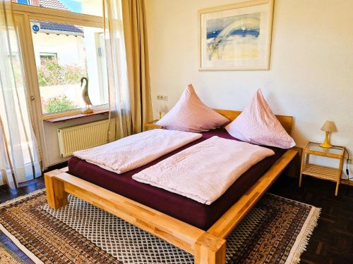 a bed with two pillows on it in a room at Freiburg citynah - hell, ruhig, gemütlich in Freiburg im Breisgau