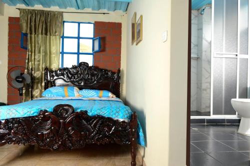 1 dormitorio con 1 cama con edredón azul y ventana en Alex Country House, en Chachagüí