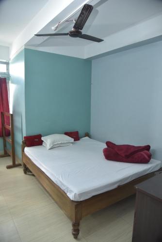 uma cama num quarto com uma ventoinha de tecto em Bibhas Lodge & Restaurant em Guwahati