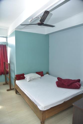 Bibhas Lodge & Restaurant في غاواهاتي: سرير في غرفة مع ضوء على السقف
