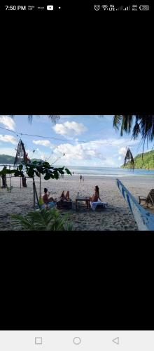 a group of people sitting on a beach at 8 Star Paradise in Locaroc