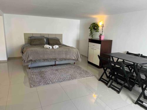a bedroom with a bed and a table and chairs at Linda Casa com amplo jardim! in Curitiba