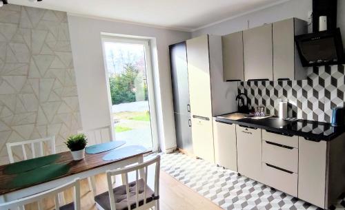 a kitchen with white cabinets and a table at Dom Przyjaźni in Kędzierzyn-Koźle