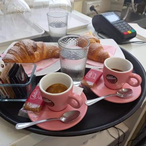 a tray with two cups of coffee and pastries at Casa Vacanza Nonna Anna in Manfredonia