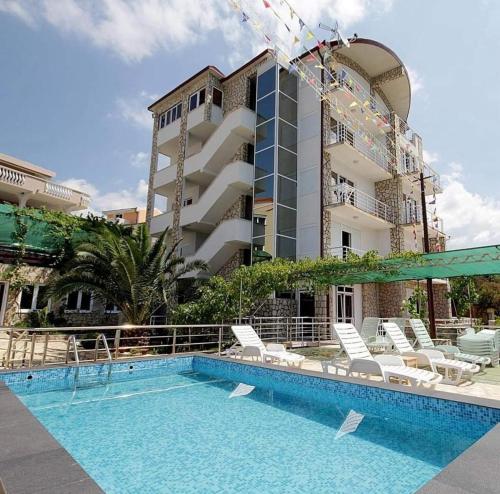 um hotel com piscina em frente a um edifício em Villa Victoria em Utjeha