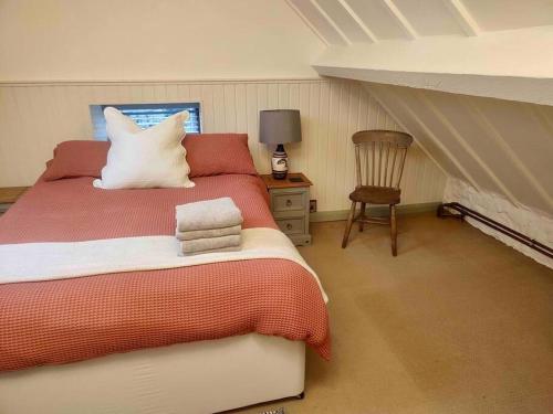 een slaapkamer met een groot bed en een stoel bij Pandy Farmhouse - Panoramic mountain views within Snowdonia's National Park - 4x4 recommended in Dolgellau