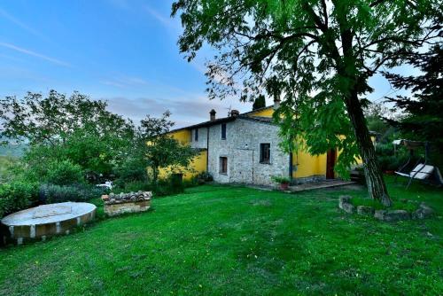a stone house with a tree in the yard at Agriturismo Corvaia in Radicofani