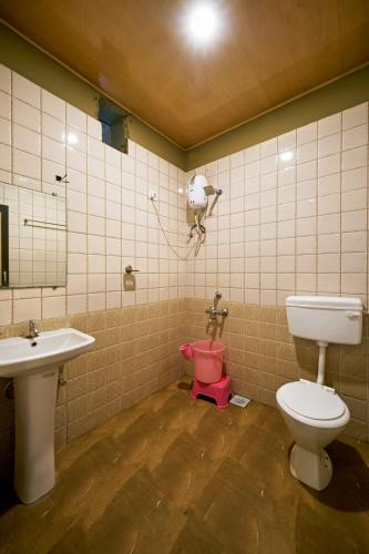 a bathroom with a toilet and a sink at Serenity Resort Panhala in Panhāla