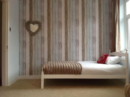 een slaapkamer met een bed met een hartwand bij Cardiff House 62 - CENTRAL LOCATION in Cardiff