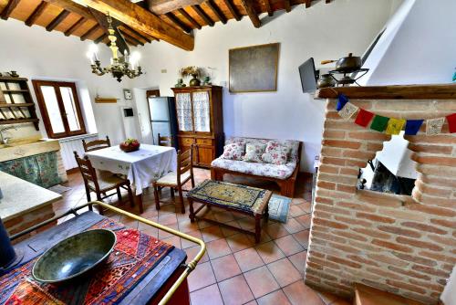a living room with a brick fireplace and a table at Agriturismo Corvaia in Radicofani
