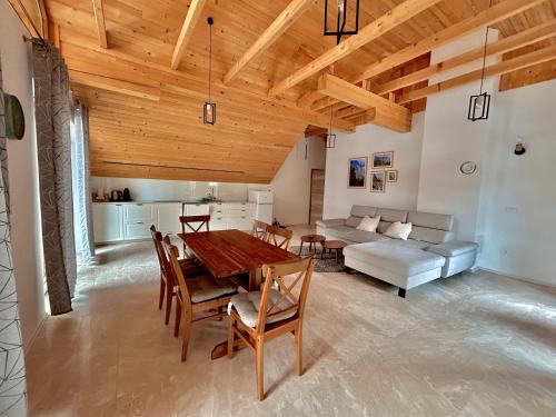 a living room with a wooden ceiling and a table and chairs at ALPS Apartments in Kranjska Gora