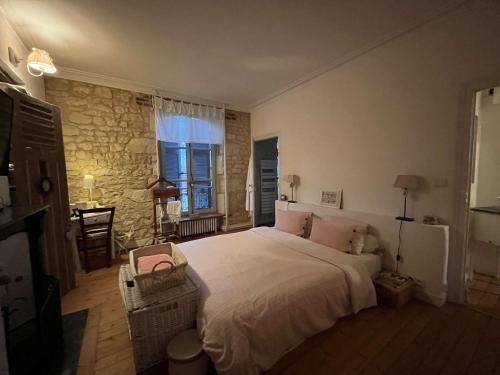 - une chambre avec un grand lit et un mur en pierre dans l'établissement Chambres d'hôtes de charme sur LE MANS, au Mans