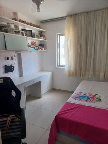 una camera da letto con scrivania, letto e finestra di Apartamento vista Mar a Salvador