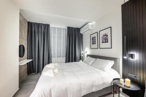 a bedroom with a large white bed and a window at Cozyio- Ioannina City Center, Luxury Accommodation in Ioannina