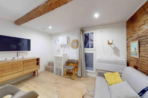 un salon avec un canapé et une télévision dans l'établissement Studio classé au cœur des Carmes, à Toulouse