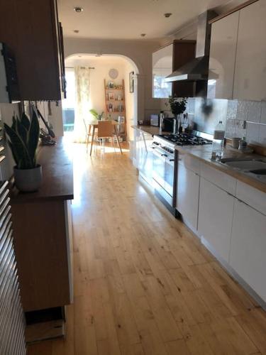 a kitchen with white cabinets and a wooden floor at Apartment with balcony West Bridgford in Nottingham