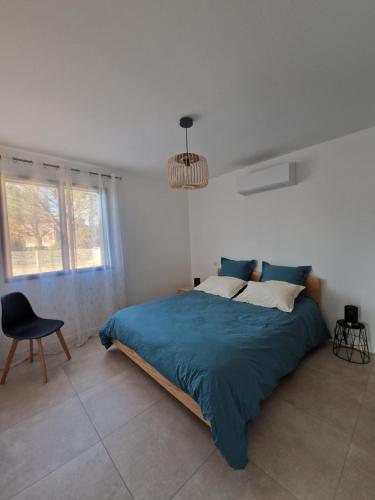 a bedroom with a large bed and a chair at Terre de Crussol - Gite 3 étoiles en Ardèche, avec piscine et clim, 2-4 personnes in Saint-Péray