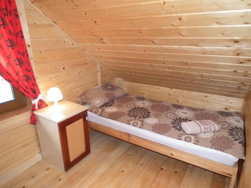Domek w Gorcach في Ochotnica Dolna: غرفة بسرير في كابينة خشبية