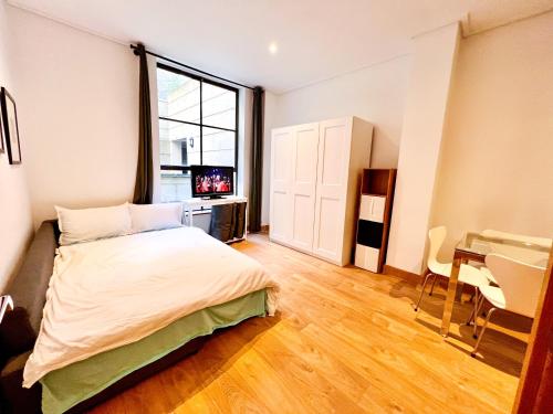 Excellent Entire Apartment Between St Pauls Cathedral and Covent Garden في لندن: غرفة نوم بسرير ومكتب ونافذة