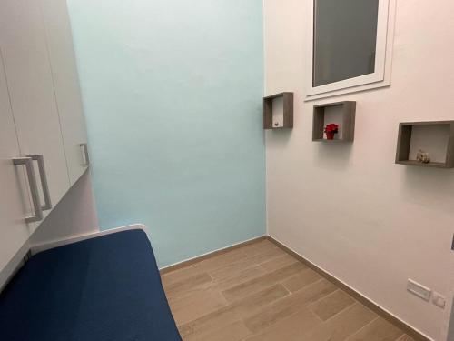 una camera con una sedia blu e una parete di Appartamento Cosy Centro Storico a Barletta